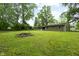 Large backyard with a well-maintained lawn, bordered by mature trees, offering privacy and space at 5422 Orange St, Indianapolis, IN 46203