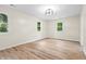 Empty bedroom featuring wood-look floors, white trim and two large windows for natural light at 5422 Orange St, Indianapolis, IN 46203