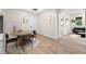 Virtually staged dining room with modern lighting and wood-look floors adjacent to entry and living room at 5422 Orange St, Indianapolis, IN 46203
