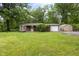 Charming single story home featuring green grass and a detached garage at 5422 Orange St, Indianapolis, IN 46203