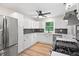 Well lit kitchen featuring stainless steel appliances, white cabinets and countertops, and wood-look floors at 5422 Orange St, Indianapolis, IN 46203