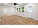 Bright living room with hardwood floors, ceiling fan, and entry door with decorative glass at 5422 Orange St, Indianapolis, IN 46203