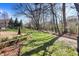 Well-maintained backyard featuring a lush lawn, mature trees, garden bed, and a wrought iron fence at 545 Walnut Woods Dr, Greenwood, IN 46142