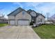 Two-story brick home with a three car garage and a well manicured lawn at 545 Walnut Woods Dr, Greenwood, IN 46142