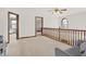 Bright upstairs hallway with carpet and wood railing at 545 Walnut Woods Dr, Greenwood, IN 46142