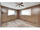 Empty bedroom with hardwood flooring, paneled walls, and dual windows, offering ample natural light at 5558 Bertha St, Indianapolis, IN 46241