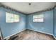 Bedroom featuring blue walls, two windows bringing in natural light, and wood floors at 5558 Bertha St, Indianapolis, IN 46241