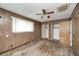 Spacious bedroom with wood paneling and a ceiling fan, awaiting your personal touch at 5558 Bertha St, Indianapolis, IN 46241