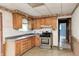 Functional kitchen with wood cabinets, white backsplash, and an easy-to-clean gas range at 5558 Bertha St, Indianapolis, IN 46241