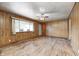 Bright living room with hardwood floors, paneled walls, and a large window letting in plenty of light at 5558 Bertha St, Indianapolis, IN 46241