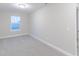 Carpeted bedroom with a window overlooking the neighborhood and white walls at 5790 Arcade Blvd, McCordsville, IN 46055