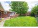Lush back yard features a small wood deck, established lawn, and beautiful shade tree at 5903 Schoolwood Dr, Speedway, IN 46224
