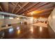 Spacious basement with exposed wood ceiling, concrete walls and floors, and a stairwell at 5903 Schoolwood Dr, Speedway, IN 46224