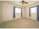 Bedroom offering neutral carpet, two windows with blue curtains, and a ceiling fan at 5903 Schoolwood Dr, Speedway, IN 46224