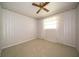 This bedroom features neutral carpet, a ceiling fan, light-colored walls and baseboards, and a bright window at 5903 Schoolwood Dr, Speedway, IN 46224