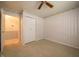 This bedroom features neutral carpet, light-colored walls and baseboards, a ceiling fan, and closet at 5903 Schoolwood Dr, Speedway, IN 46224