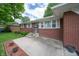 Inviting brick home entrance featuring a concrete steps and manicured landscaping at 5903 Schoolwood Dr, Speedway, IN 46224