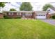 Charming brick ranch home with a well-manicured lawn and attached garage at 5903 Schoolwood Dr, Speedway, IN 46224