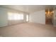 Light-filled living room with neutral carpet and access to hallway and exterior at 5903 Schoolwood Dr, Speedway, IN 46224