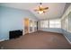 Open sunroom with blue walls, a vaulted ceiling with fan, windows and sliding door at 5903 Schoolwood Dr, Speedway, IN 46224