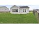 A lush green backyard featuring a well-maintained lawn, a chain-link fence, and the rear of the house with many windows at 637 N Quartz Ln, Fortville, IN 46040