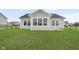 The backyard showcases a large, well-manicured lawn and a charming view of the home's rear exterior with its numerous windows at 637 N Quartz Ln, Fortville, IN 46040