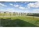The property's backyard blends into a scenic view of a pond, walking path, and neighboring houses, enclosed with a fence at 637 N Quartz Ln, Fortville, IN 46040