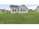An expansive, verdant backyard enclosed by a fence, offers a picturesque view of the house and the surrounding neighborhood at 637 N Quartz Ln, Fortville, IN 46040