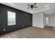Modern bedroom featuring wood floors, a trey ceiling with fan, and decorative wall at 637 N Quartz Ln, Fortville, IN 46040