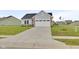 Home exterior with a long concrete driveway, leading to a two car garage, complimented by a green lawn at 637 N Quartz Ln, Fortville, IN 46040