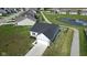 An aerial view of a house with a two-car garage and a long driveway located near a pond at 637 N Quartz Ln, Fortville, IN 46040