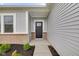 Stylish front entrance with gray siding, brick accents, and a modern black front door at 637 N Quartz Ln, Fortville, IN 46040