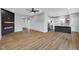 Spacious living room with a fireplace, open to the modern kitchen with beautiful wood flooring at 637 N Quartz Ln, Fortville, IN 46040