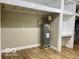 Basement utility area with shelves and an updated water heater at 6373 E Hadley Rd, Mooresville, IN 46158