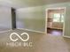 Carpeted living room featuring neutral walls and an open doorway to the kitchen at 6373 E Hadley Rd, Mooresville, IN 46158