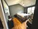 Cozy bedroom with laminate wood flooring, a decorative light fixture, and a bright window at 6640 Sundown S Dr, Indianapolis, IN 46254