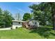 View of home's backyard with deck and barbecue area, complemented by mature trees at 6799 Lakeshore Dr, Avon, IN 46123