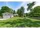 Lush backyard with a fire pit, multi-level deck, mature trees and manicured lawn creating a private oasis at 6799 Lakeshore Dr, Avon, IN 46123