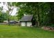 Spacious two-car detached garage nestled amongst mature trees and lush greenery in a private backyard at 6799 Lakeshore Dr, Avon, IN 46123