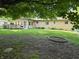 The backyard features a fire pit, a brick home, and mature landscaping for outdoor enjoyment at 7015 Westlake Rd, Indianapolis, IN 46214