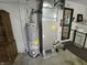 Basement utility area featuring a water heater, furnace, and laundry setup for essential home systems at 7015 Westlake Rd, Indianapolis, IN 46214