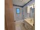 A classic bathroom with a shower-tub combo, white cabinets, and a window for natural light at 7015 Westlake Rd, Indianapolis, IN 46214