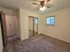 This carpeted bedroom has a closet with mirrored doors, a window and a ceiling fan at 7015 Westlake Rd, Indianapolis, IN 46214