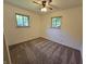 This carpeted bedroom has two windows for natural light and a ceiling fan at 7015 Westlake Rd, Indianapolis, IN 46214