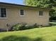Exterior brick wall of home with garden and well-maintained lawn at 7015 Westlake Rd, Indianapolis, IN 46214