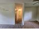 View of carpeted hallway that connects rooms with neutral-colored walls and wood trim at 7015 Westlake Rd, Indianapolis, IN 46214