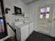 Bright laundry room featuring a washer and dryer, with easy access to the outside at 7015 Westlake Rd, Indianapolis, IN 46214