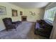 Living room area with large windows, floral print armchair and love seat, as well as a fireplace at 7015 Westlake Rd, Indianapolis, IN 46214