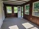 Sun room with carpet and wood paneled walls, including a door to the outside at 7015 Westlake Rd, Indianapolis, IN 46214