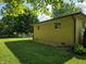 Side yard featuring a grass lawn and brick walls with small windows at 7015 Westlake Rd, Indianapolis, IN 46214